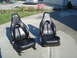 1995 Ford Probe - Pair of black leather bucket seats, likely for a sports car, displayed outdoors on a concrete surface.