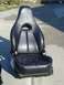 1995 Ford Probe - A black leather car seat is shown outdoors, possibly for sale or replacement.