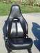 1995 Ford Probe - A single black leather car seat is shown outdoors, with a red seatbelt buckle visible.