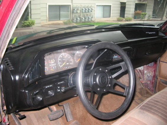 Dashboard with steering wheel, gauges, and vents. Text on dash reads "Bronco"