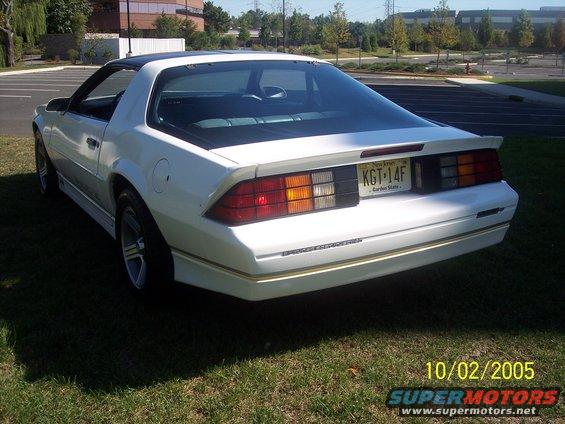 White 1988 Chevrolet Camaro parked on grass, rear 3/4 view