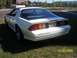 1988 Chevrolet Camaro - A white 1988 Chevrolet Camaro is shown from the rear 3/4 angle, parked on a grassy area.