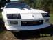 1988 Chevrolet Camaro - Front view of a white 1988 Chevrolet Camaro, distinctive black hood vents and the iconic Chevrolet bowtie emblem.