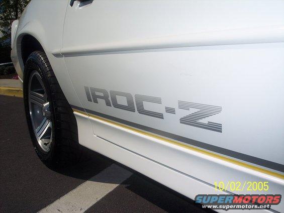 Side view of a white car with an IROC-Z decal and a yellow stripe