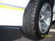 1988 Chevrolet Camaro - Close-up of a car's wheel and tire, showing a yellow stripe on the white bodywork.