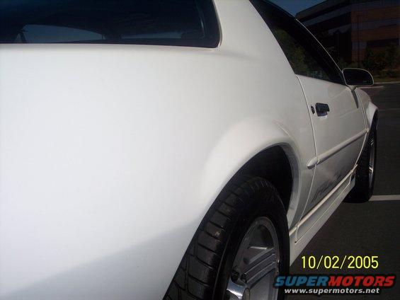White 1988 Chevrolet Camaro rear quarter panel, showing the wheel and side molding