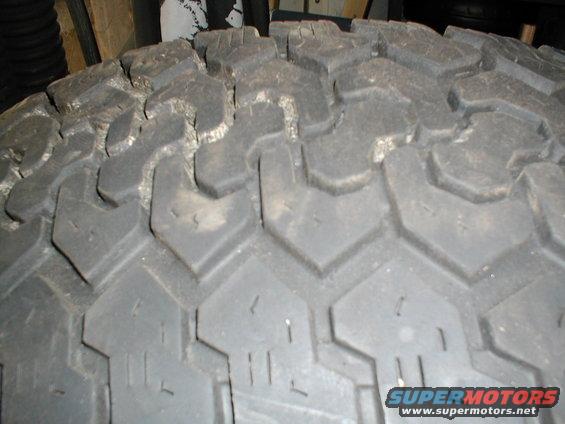 Close-up of a tire tread with Supermotors.net watermark