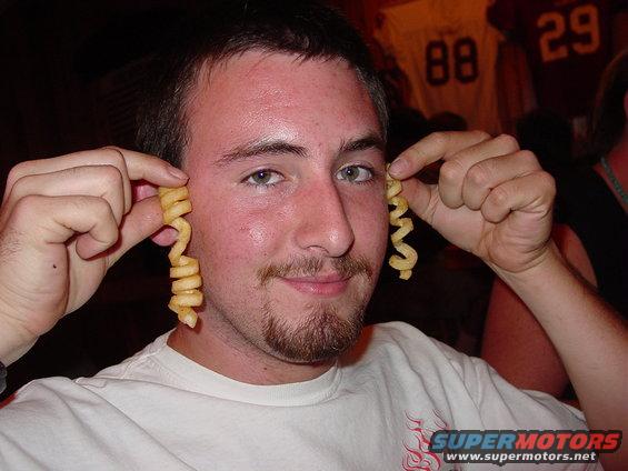 Man holding curly fries to his ears, with SuperMotors logo at bottom right