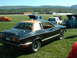 1978 Ford Mustang II - A black 1978 Ford Mustang II coupe with a tan roof sits on a grassy field next to other vehicles.