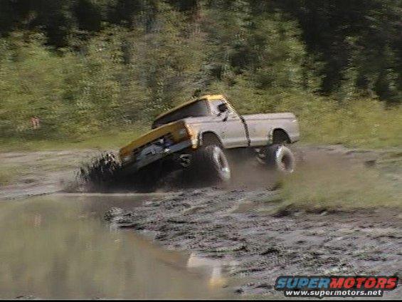 Pickup truck driving through mud. Looks like a 1979 Ford F-250