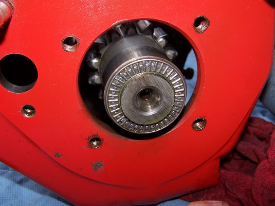 Close-up of a transmission gear and bearing assembly inside a red housing