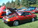 1978 Ford Mustang II - A red coupe with its hood and trunk open is displayed outdoors with other vehicles.