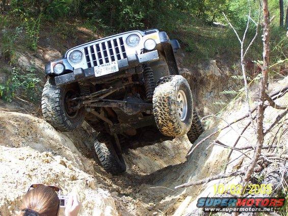 Silver Jeep Wrangler TJ navigating a steep dirt incline