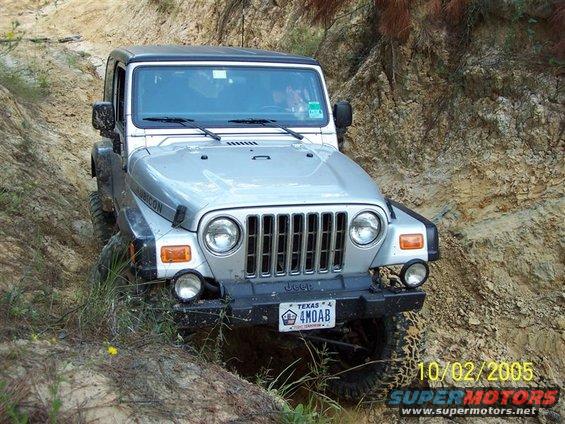 Jeep Wrangler Rubicon driving off-road on a dirt path