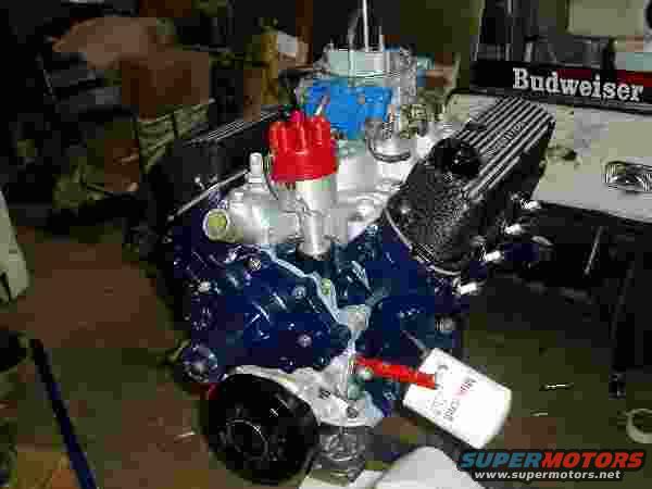 Blue engine with red distributor cap and Budweiser logo in background