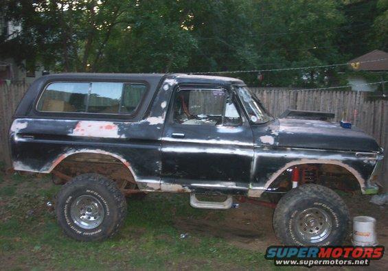 1978 Ford Bronco with a hood scoop and lifted suspension, sitting in a yard