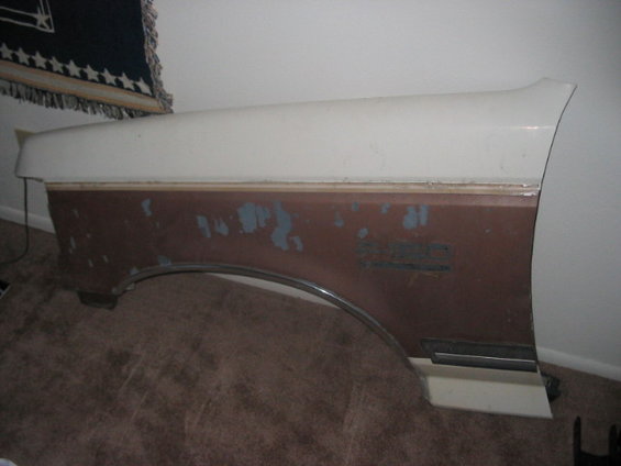 vehicle fender with peeling paint and a chrome trim piece