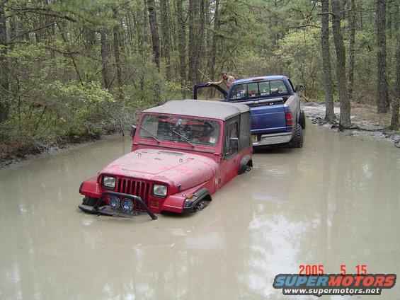 Red Jeep Wrangler and blue pickup truck stuck in a muddy forest trail. Date stamp reads 2005 5 15