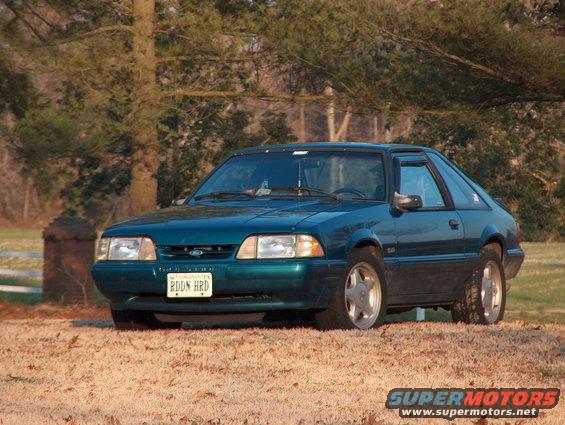 1993 Ford Mustang coupe, teal green, parked outdoors on dry grass