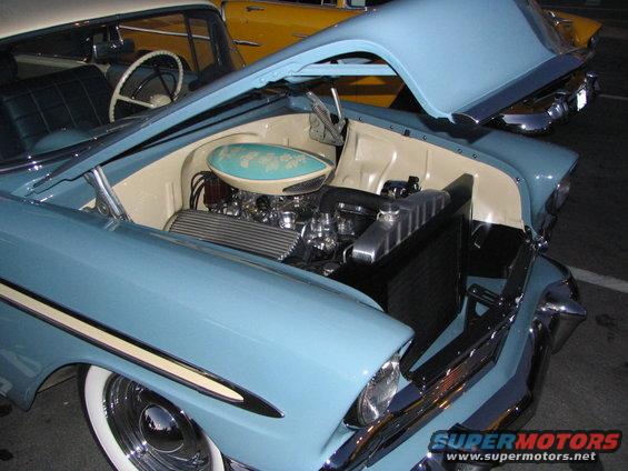 Light blue 1957 Chevrolet Bel Air engine bay with chrome details and a turquoise air cleaner