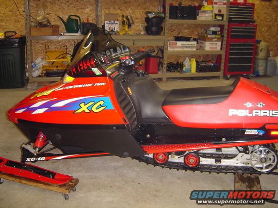 Red and black Polaris snowmobile with XC graphics