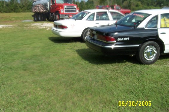 Black and white police car rear view with "Dial 911" text