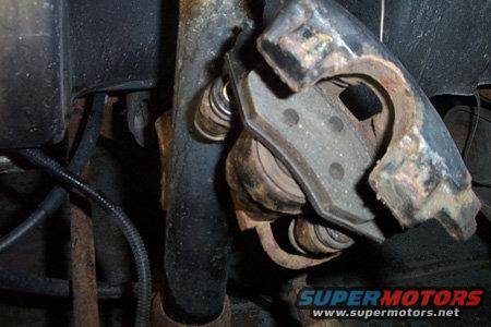 Close-up of a rusty brake caliper assembly with brake pads visible