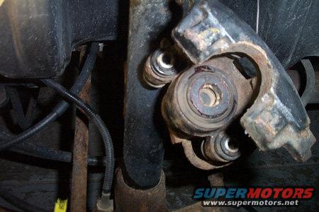 Close-up of a rusty suspension part with rubber bushings