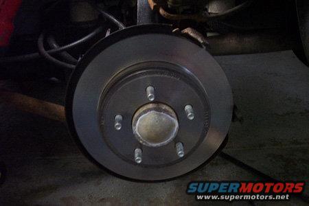 Disk brake rotor with five lug nuts visible