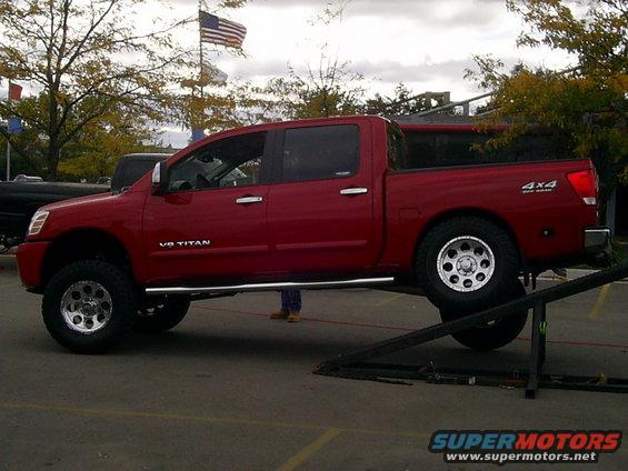 Red pickup truck with V8 TITAN badging and 4x4 emblem