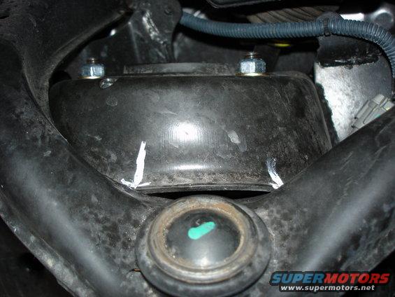 Close-up of a vehicle's suspension with bolts and markings