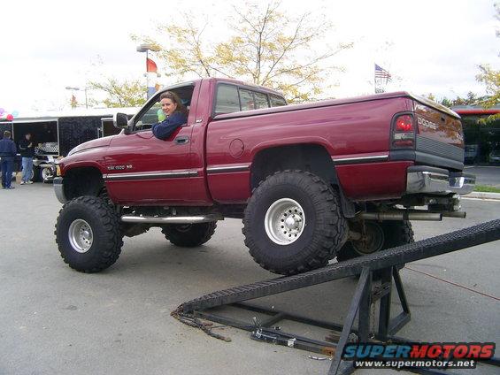 Lifted red Dodge Ram pickup truck, driver's side view. This is a 1994-2001 generation Dodge Ram
