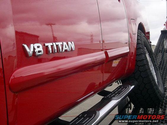 Red truck side with V8 TITAN badge and running boards