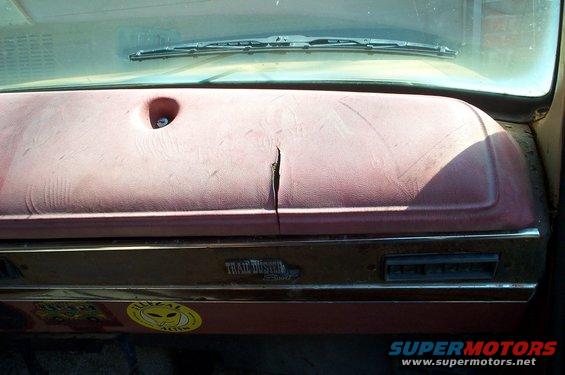 Cracked maroon dashboard with 'Trail Duster' emblem and 'Illegal Alien' sticker