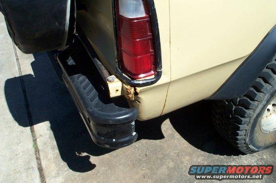 Yellow truck rear bumper with spare tire mount, red taillight, and black fender flare