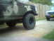 1988 Ford Bronco - A camouflaged SUV with off-road tires is parked next to another vehicle in a driveway.