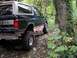 1995 Ford Bronco - Lifted 1995 Ford Bronco navigating a wooded trail.