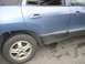 1999 Ford Taurus - Side view of a blue SUV, revealing its rear door, wheel, and protective black trim along the lower body.