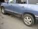1999 Ford Taurus - Side view of a blue SUV, likely a Hyundai Santa Fe, parked outdoors.