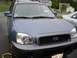 1999 Ford Taurus - A blue Hyundai Santa Fe SUV is parked in a driveway, with a silver sedan visible to its right.