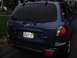 1999 Ford Taurus - The rear of a blue Hyundai Santa Fe SUV is shown, with a license plate and visible badging.