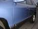 1999 Ford Taurus - Close-up of the side panel and wheel well of a blue SUV.