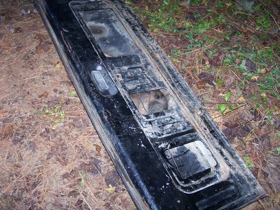 Black tailgate section with rectangular cutouts and a handle mechanism