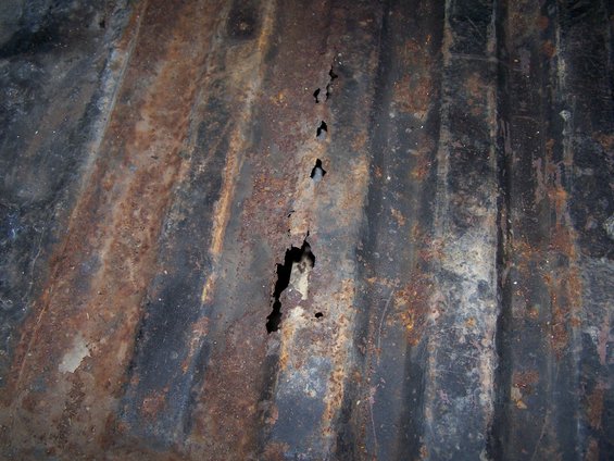 corrugated metal with holes and rust