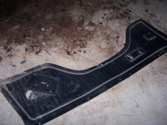black car door panel with ribbed texture and a diamond-shaped inset