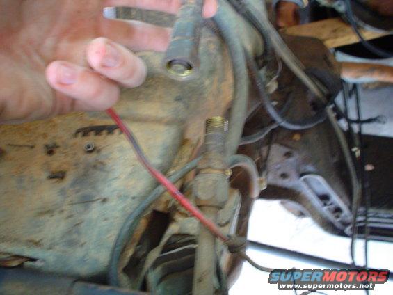 Hand holding wire near engine components