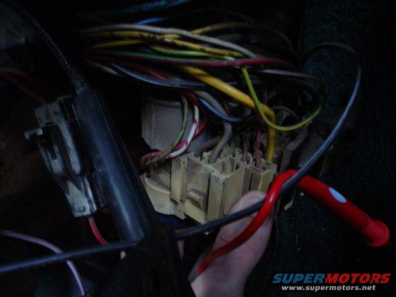Close-up of a vehicle's interior wiring harness and fuse box