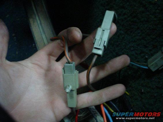hand holding two electrical connectors with wires