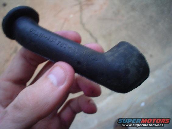 Black rubber hose part with embossed text D2AH-1A703-AA held by a hand