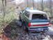 1989 Ford Bronco - A 1989 Ford Bronco navigates a challenging, rocky off-road path with another vehicle in the distance.